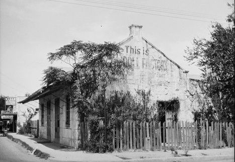 Image is a corner perspective of single story commercial building on Lakeview Avenue. The building is rundown, with its trees overgrown. The image is from the David Reichard Williams collection.