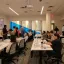 The Scholars Lab Data Lab with rows of desks, computers, and individuals facing the front where a presentation is taking place.